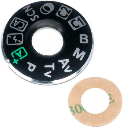 Camera mode dial cover plate: black circular labeled ring with beige gasket