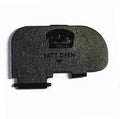 Battery door cover, black textured plastic with latch tab and embossed marking