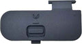 Camera battery chamber cover in black plastic with latch and thumb button