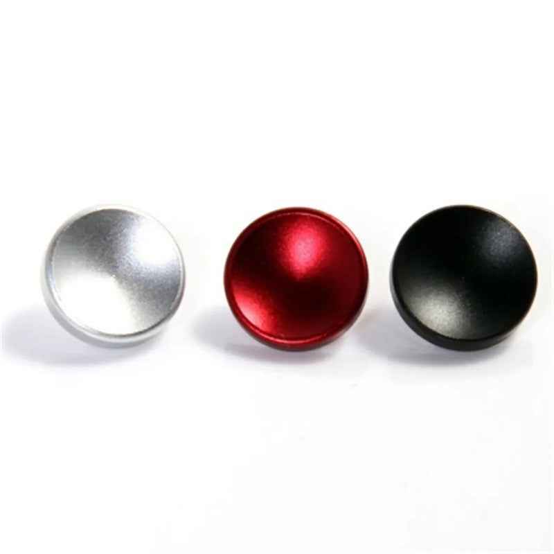 Round metal shutter release button caps in silver, red, and black